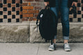 Person standing against a concrete wall wearing a pack