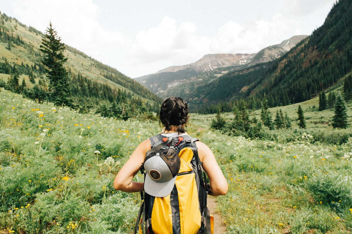 Person carrying a loaded pack on a trail