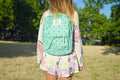 Person wearing a green backpack outdoors