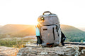 Hiking pack and a bottle on rock at sunset