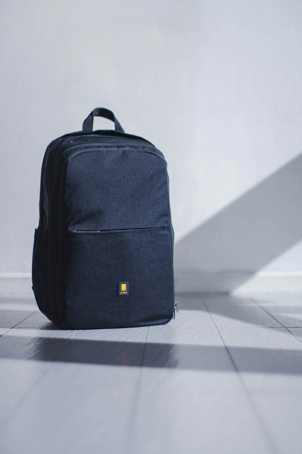 Backpack standing upright on a pale floor