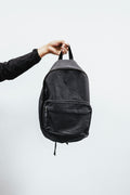 Person holding a large black backpack