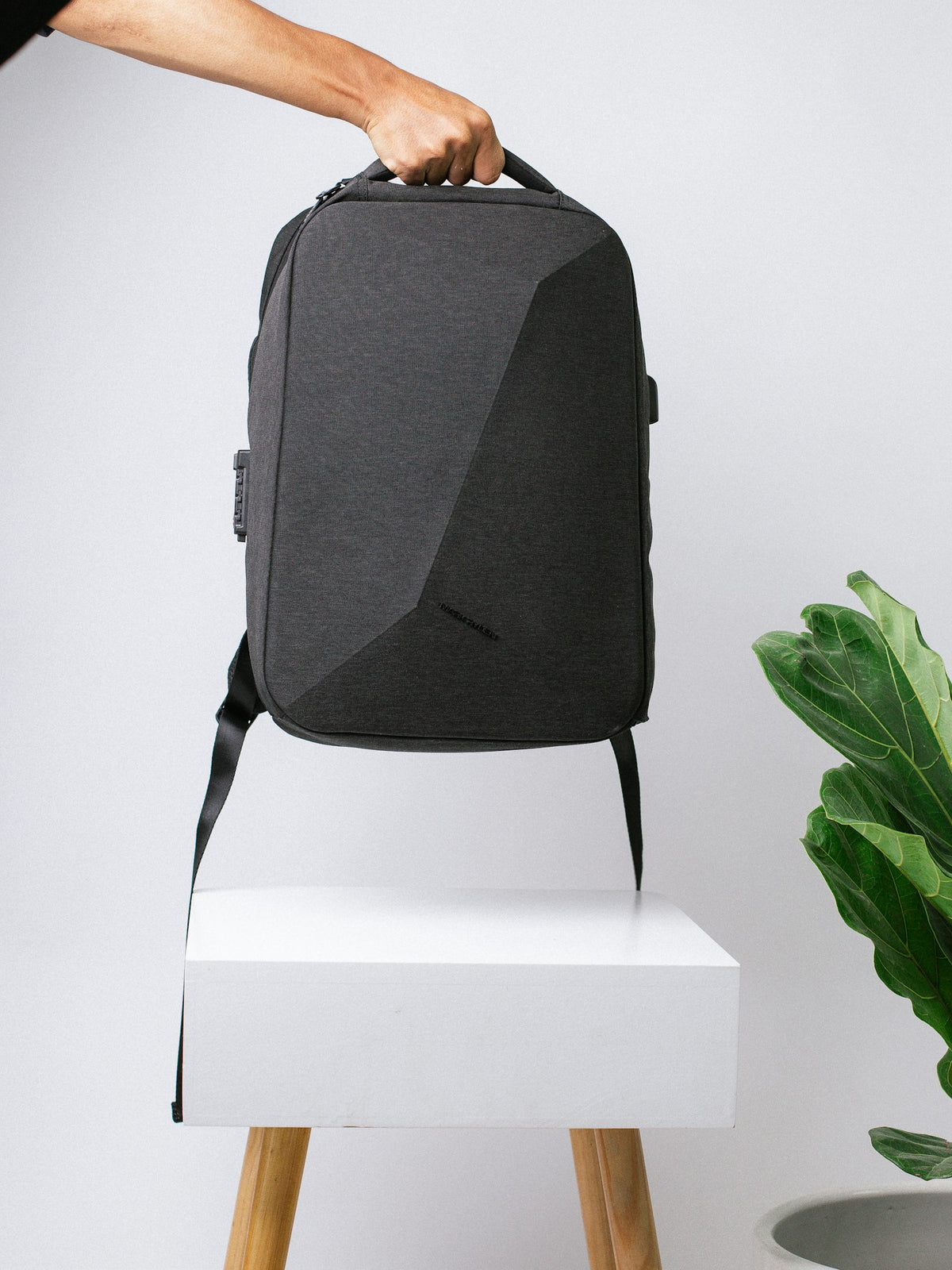 Black backpack photographed on a white surface