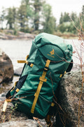 Green and brown backpack resting on rock