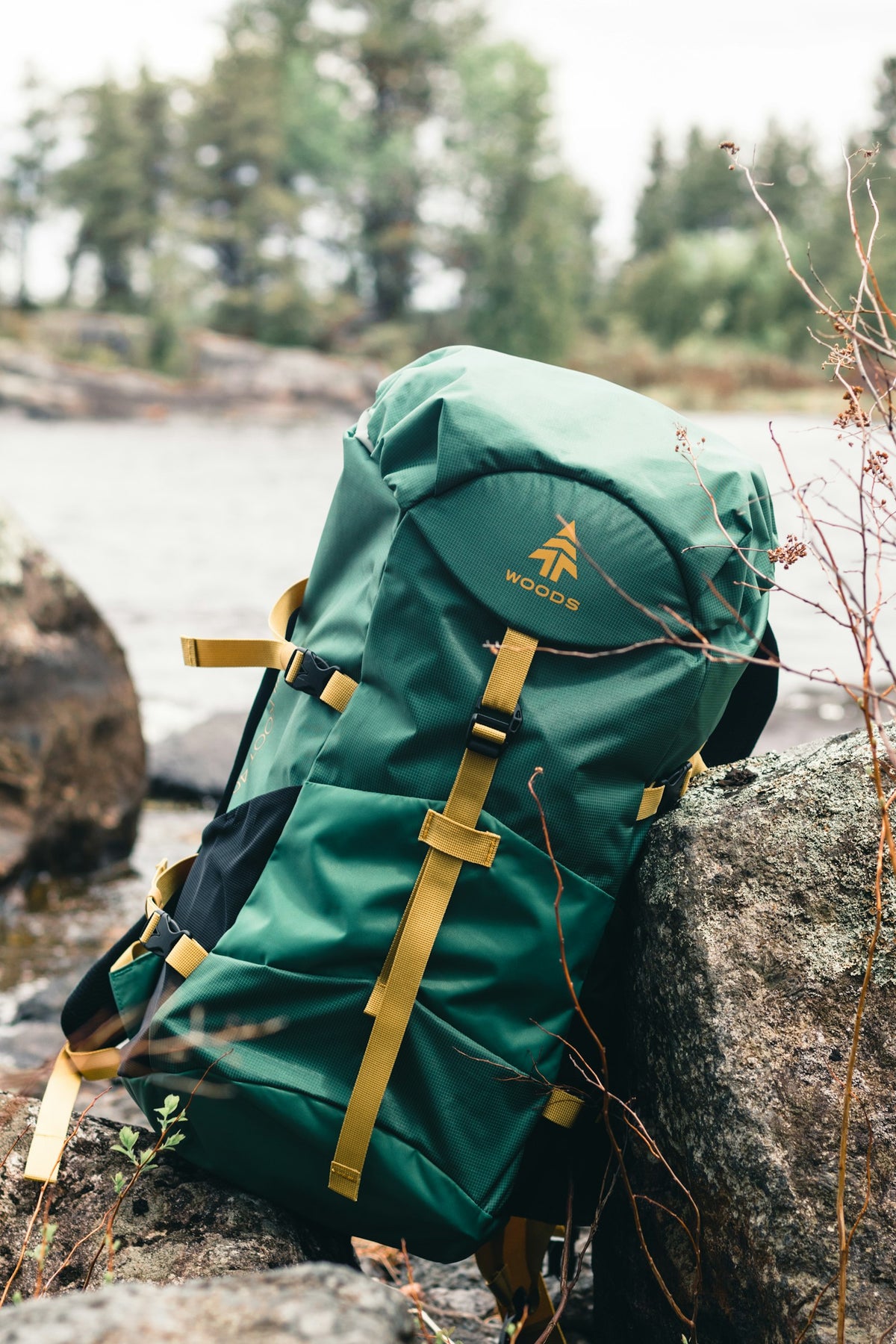 Green and brown backpack resting on rock