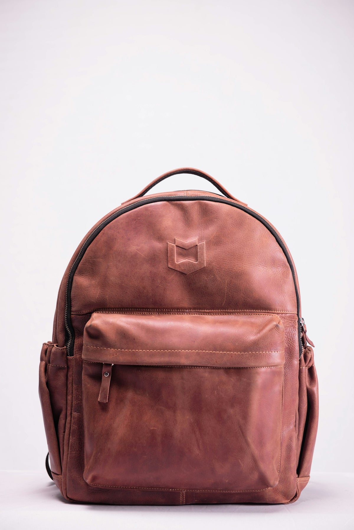 Brown leather backpack on a light surface