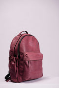 Leather backpack against a pale wall