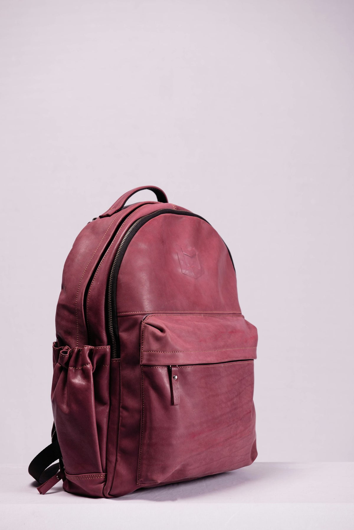 Leather backpack against a pale wall
