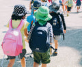 People walking along a road with backpacks