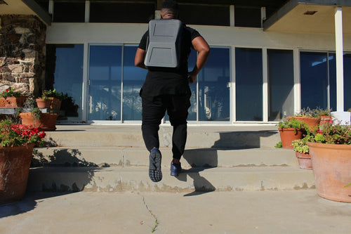 Person walking outdoors wearing a backpack