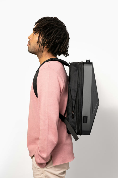 Person wearing a dark backpack outdoors