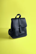 Black leather backpack on a plain backdrop