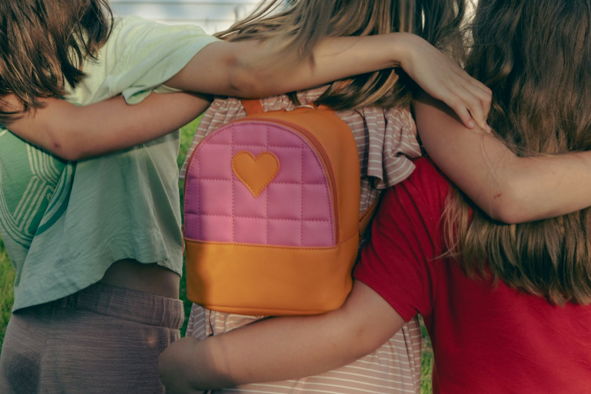 Group of children together wearing school packs